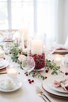 a white table topped with plates and candles