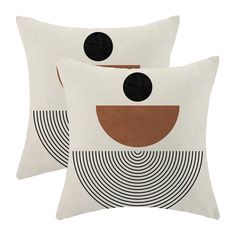 two white pillows with black and brown circles on the front, one has a circular design