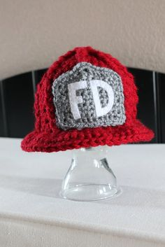 a crocheted hat with the letter fd on it sitting on a table