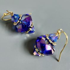 "Purple and Gold  Earrings - Glass Iridescent Purple  Beads with Gold Plated Beadcaps and Iridescent Purple Bacon Glass Beads. These earrings have a lot of sparkle and are gorgeous when the light hits them. The Beads are approximately 14mm wide Gold plated Earwires Earrings measure  1.25\" long from top of earwire to bottom" Elegant Handmade Iridescent Earrings, Elegant Iridescent Pierced Earrings, Iridescent Wire Wrapped Drop Earrings, Iridescent Drop Earrings For Formal Occasions, Purple Wire Wrapped Jewelry For Party, Party Wire Wrapped Purple Jewelry, Party Purple Wire Wrapped Jewelry, Party Wire Wrapped Beaded Earrings, Pierced Iridescent Jewelry For Party