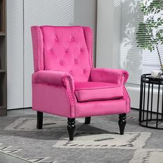 a pink chair sitting on top of a rug