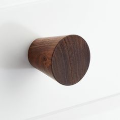 a close up of a wooden knob on a white wall