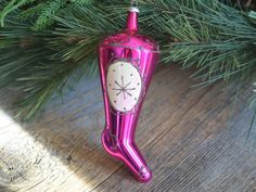 a pink christmas ornament hanging from a tree