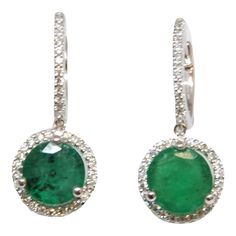 These gorgeous 2.91 ct round emerald & diamond earrings set in 18k white gold are sure to turn heads. Featuring 78 diamonds surrounding the 2 emeralds, they are definitely a great addition to any wardrobe. The diamonds boast a color of F/G and VS1 in clarity. Luxury Round Emerald Diamond Earrings, Green Diamond Round Cut Earrings, Green Pave Setting Fine Earrings, Emerald Earrings With Diamond Accents, Green Round Earrings With Halo Setting, Green Brilliant Cut Round Diamond Earrings, Emerald Halo Setting Round Earrings, Green Diamond Earrings With Brilliant Cut, Round Emerald Earrings With Halo Setting