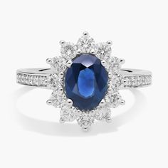 an oval blue sapphire and diamond ring with white diamonds around the band, set in 18k white gold