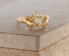 a close up of a gold ring with a heart shaped diamond in it's center