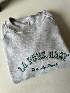 LA Push Baby Embroidered Sweatshirt, Hoodie, T-shirt, Slogan, Varsity, Unisex FOLLOW THESE 5 STEPS TO ORDER: 1. Please check the listing photos for size guides, colour of garments, font options, thread colours  2. Select the colour (If you want a different colour which is not listed up, message us) 3. Select your size (S-XXL) 4. 'Add your personalisation' choosing thread colours  EXAMPLE THREAD COLOUR - 27 5. Ensure you write your personalisation text EXACTLY how you want it embroidered includin Gray Tops With Embroidered Logo For Streetwear, Gray Embroidered Logo Top For Streetwear, Green Letter Print Hoodie, Green Letter Embroidery Sweatshirt For Streetwear, Green Sweatshirt With Letter Embroidery For Streetwear, Green Sporty Sweatshirt With Embroidered Graphics, Green Embroidered Sporty Sweatshirt, Cotton Sweater With Letter Embroidery For Streetwear, Embroidered Hoodie Top For Streetwear