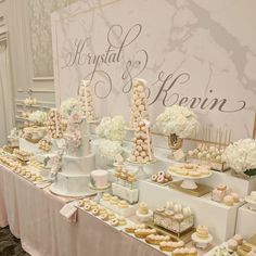 a table filled with lots of desserts and pastries on top of white tables