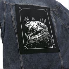 a black and white photo of a person wearing a jean jacket with an alligator head on it