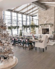 a living room filled with furniture and a christmas tree in the middle of the room