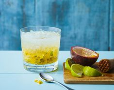 a glass filled with lemonade next to an orange and lime on a cutting board