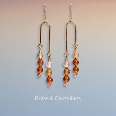 One pair of handmade earrings with 12 Carnelian stones (6mm) and small glass beads (1x2mm). These Earrings are shaped by hand and hardened by hammering to make it stronger and harder. Metal used is nickel safe Tarnish Resistant Brass - Artistic Wire®. The color of the stones can vary due to different lights and screens. ❀ ❀ ❀ Carnelian is said to be a stone of courage, endurance, energy, leadership and motivation. ❀ ❀ ❀ Take care of your earrings: - Avoid contact with moisture and chemicals (wat Adjustable Carnelian Dangle Earrings, Carnelian Wire Wrapped Earrings For Gift, Carnelian Wire Wrapped Earrings As Gift, Adjustable Carnelian Earrings With Natural Stones, Gift Carnelian Wire Wrapped Earrings, Carnelian Gold Earrings With Ear Wire, Gold Carnelian Earrings With Ear Wire, Handmade Adjustable Carnelian Earrings, Carnelian Dangle Jewelry For Pierced Ears