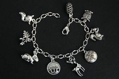 A collection of silver plated woodland themed charms have been dispersed around a shimmering silver plated bracelet chain in this handmade charm bracelet. This nature lover charm bracelet is then completed with a lobster clasp and a 1/2 inch of chain at the end for adjustable sizing. Charms in this bracelet include a rabbit charm, squirrel charm, pair of acorns charm paired with a leaf charm, a fox charm, owl charm, dragonfly charm, pine cone charm, copse of trees charm, and a deer charm. ● Sizi Whimsical Silver Charms For Gifts, Whimsical Silver Dangling Charms, Whimsical Nickel Free Charm Bracelet Gift, Whimsical Nickel-free Charm Bracelet Gift, Silver Charm Bracelet With Vintage Charm As A Gift, Silver Vintage Charm Bracelet Gift, Nature-inspired Silver Jewelry With Charms, Silver Charm Bracelet With Dangling Charms For Gift, Silver Charm Bracelet With Dangling Charms As Gift