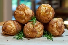 some food that is sitting on top of a wooden table with green sprigs