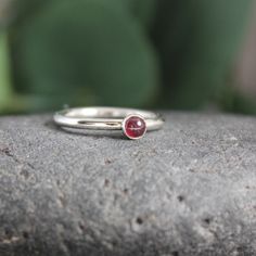 Garnet symbolizes love and is the gemstone to give for the 2nd anniversary. It is also the birthstone for January. This simple sterling silver stacking ring is a great gift, or an addition to a collection of stacking rings. Here are the details: This ring is made with a 4mm or 5-6mm bezel set garnet cabochon set on a sturdy sterling silver band handmade in your size. It can be worn with other stackable rings, or by itself.Please select your ring size. Sizes are US based. Classic Everyday Stackable Gemstone Rings, Everyday Solitaire Stackable Rings, Adjustable Ruby Birthstone Ring In Fine Jewelry Style, Classic Stackable Birthstone Ring For Promise, Classic Stackable Birthstone Promise Ring, Adjustable Ruby Birthstone Ring, Fine Jewelry, Stackable Sterling Silver Birthstone Ring Fine Jewelry, Stackable May Birthstone Rings With Round Band, Everyday Stackable Birthstone Ring In Fine Jewelry Style