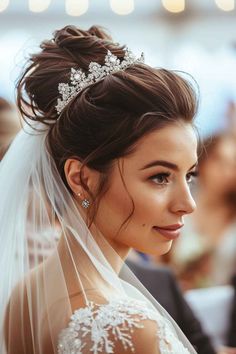 a woman in a wedding dress with a veil and tiara on her head, looking off to the side