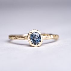 Details: Hand Forged 18k Gold solitaire ring with a beautiful Steely Blue Hand Cut Montana Sapphire. A truly one of a kind ring, old mine cut sapphire cut to the original shape of the rough. Ethically sourced, cut by hand in my Brooklyn Studio.  Set in 18k Recycled Gold, cast in wood and made by hand. Metal: 18K Yellow Gold Stones: Sapphire 0.510ct Montana Sapphire Please note: Each piece is truly unique from every other as a result of the hand forged process. Please expect a genuinely one-of-a- Montana Sapphire Engagement Ring, Montana Sapphire Ring, Sapphire Solitaire Ring, Sapphire Wedding Rings, Yellow Rings, Diamond Stacking Rings, Gold Solitaire Ring, Sapphire Solitaire, Blue Stone Ring