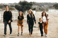 a group of people walking down a dirt road