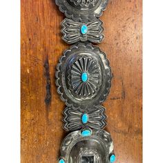 This old Navajo Concho belt with its cross hallmark on the buckle is the work of Navajo silversmith Etsitty Tsosie.  Set with turquoise throughout and strung on a buffalo hide strap.  Strap measures 40.5" long.  Buckle measures 4" x 3 1/4".  Round conchos measure 3 3/4" x 3 1/4".  Good condition with pleasing old surface. Southwestern Turquoise Concho Belt Buckles, Cowgirl Bling, Zuni Jewelry, Concho Belt, Vintage Navajo, Silver Turquoise, Hallmark, Buffalo, Belts