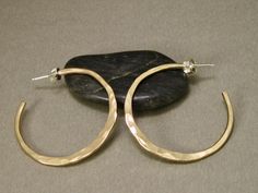 These gold filled hoop earrings are made from 12 gauge wire, so they're strong and have a lot of substance to them. They've  have been hand shaped and hammered individually, and then tumbled for strength and polished for a high shine. Sterling posts and ear nuts give it  that continuous flow and a secure fit to the ear lobe. A classic look that never goes out of style.  Made to order, so allow 10 working days for fabrication.  I always have some of these in stock, so check with me for available Cadmium-free Brass Small Hoop Jewelry, Cadmium-free Hoop Brass Jewelry, Cadmium-free Brass Hoop Jewelry, Small Hoop Hammered Gold Jewelry, Gold Hammered Small Hoop Jewelry, Small Hammered Gold Hoop Jewelry, Hypoallergenic Gold Hoop Earrings In Recycled Gold, Hypoallergenic Gold Hoop Earrings In Recycled Material, Hypoallergenic Recycled Gold Hoop Earrings