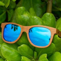 The Sunset Classic with Blue lens is inspired by the deep blue. With a lightweight design that floats on water this pair is sure to be your go-to sunglasses for all your beach days in Waikiki. The sunglasses feature an engraved tribal design on each arm and natural finished wood to promote durability. Product Details: Made from Cherry Wood Blue Mirror Polarized Lens UVA/UVB Protection Eco friendly sunglasses Unisex style Wayfarer Sunglasses With Mirrored Lenses For Vacation, Beach Wayfarer Sunglasses With Mirrored Lenses, Wayfarer Sunglasses With Uv Protection For Beach, Uv Protection Wayfarer Sunglasses For Beach, Summer Wayfarer Sunglasses For Outdoor Activities, Trendy Blue Sunglasses For Outdoor Activities, Blue Sunglasses With Tinted Lenses For Outdoor Activities, Modern Blue Sunglasses For Vacation, Summer Polarized Sunglasses For Outdoor Activities