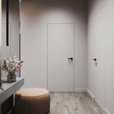 a white room with a stool, mirror and closet doors on the wall next to it