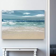 an ocean scene with waves crashing on the beach and blue sky above it, framed in white