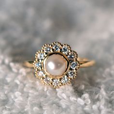 a close up view of a ring with pearls and diamonds on the inside of it