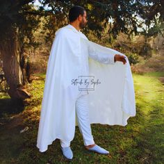 This is a white linen hooded cloak,  comfort and elegance in a one-size-fits-all design. The natural linen material offers a breathable quality, perfect for various occasions, while its universal sizing ensures a comfortable fit for anyone. The addition of a hood adds a touch of classic style, , suitable for both casual and more formal events. White Long Sleeve Cape For Spring, White Hooded Outerwear With Double-lined Hood, White Hooded Jacket With Double-lined Hood, Hooded White Cotton Poncho, White Hooded Cloak, White Long Sleeve Spring Cape, Oversized White Cape Outerwear, Hooded Cloak, Linen Material