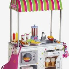 a toy kitchen with an oven, sink and umbrella over the stove top for cooking