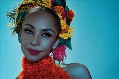 a woman with flowers in her hair wearing an orange scarf