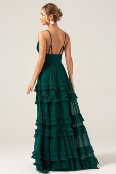 a woman wearing a green dress with ruffles on the skirt and backless top