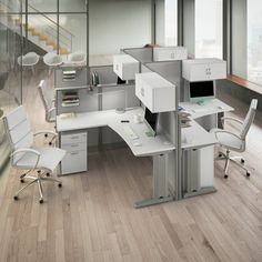 an office cubicle with desks, chairs and shelves in the middle of it