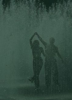 two people standing in front of a water fountain