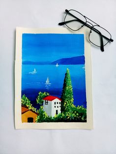 a pair of glasses sitting on top of a piece of paper next to a painting