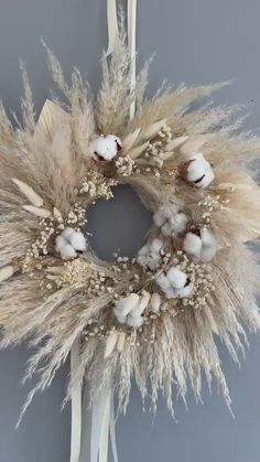 a wreath made out of cotton and dried flowers