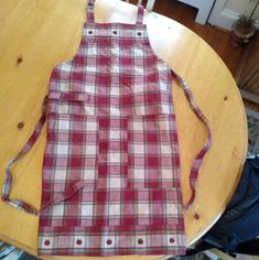 a red and white checkered apron sitting on top of a wooden table