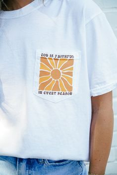 Product Details: Embrace the power of faith with our God Is Faithful Pocket Tee. This white tee boasts a vibrant sunshine detail and features the inspiring message "God is faithful in every season". With a comfortable fit and a Christian theme, this tee is perfect for spreading positivity and uplifting spirits. Product Material: 100% Cotton Hope's Go-To Outfit: "I love pairing this tee with a comfy pair of leggings or biker shorts to go run errands in!" Sizing Info: Model is 5'1" and wearing siz Inspirational White T-shirt For Everyday, White Inspirational Relaxed Fit T-shirt, Inspirational White Cotton T-shirt, Inspirational White Tops For Everyday Wear, White Inspirational Everyday T-shirt, Inspirational White T-shirt, Everyday Inspirational White T-shirt, God Is Faithful, Spreading Positivity