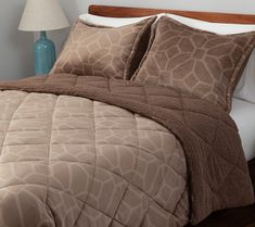 a bed with giraffe print comforter and pillows