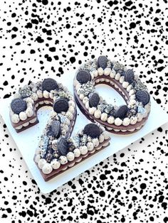 a cake shaped like the number 50 on top of a white plate with black and white sprinkles