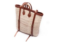 Handwoven rectangular Straw Backpack, with a brown leather handle and double adjustable straps, with leather edges to give it a flaweless frame and a unique look. This nature friendly backpack is perfect for any occasion and will carry your items for a picnic or a beach day as well as for daily usage. This could be your new elegant accessory to enjoy a long waited summer. Don't forget your sunscreen! This bag is made of natural high quality Doum which is harvested in the city of Taza, known for Brown Double Handle Backpack With Top Carry Handle, Rectangular Backpack With Adjustable Strap, Casual Rectangular Backpack For Shopping, Rectangular Backpack For Daily Use, Square Brown Backpack For Travel, Brown Square Backpack For Travel, Brown Summer Backpack, Brown Standard Backpack For Summer, Rectangular Shoulder Bag With Leather Trim