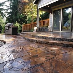 an outdoor patio with steps leading up to the front door and grill in the background