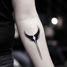 a woman's arm with a black and white tattoo design on the left forearm