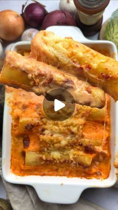 an image of food being served in a casserole dish with vegetables and sauce