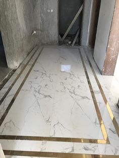 an unfinished room with white marble floors and gold trimmings on the floor,