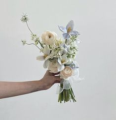 a person holding a bouquet of flowers in their hand