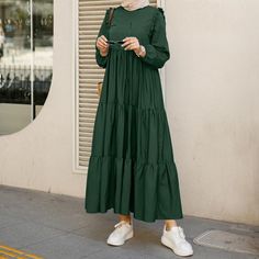 Our Casual Smock Tiered Maxi Dress is a one hit wonder. It features a round neckline, long sleeves with elasticized cuffs, ruffled trims, and a loose fit. The maxi cotton-blend fabric flows down into tiered panels like a waterfall while still hugging your curves. Complete this look with a matching hijab and platform shoes for a more elevated look. Layered Tiered Button At Front Or The Way Maxi Dress Plus, Luxury Tiered Skirt Maxi Dress For Casual Occasions, Ruffle Dress Casual, Casual Abaya, Mode Ulzzang, Large Skirt, Abaya Hijab, Muslim Dresses, Spring Dresses Women