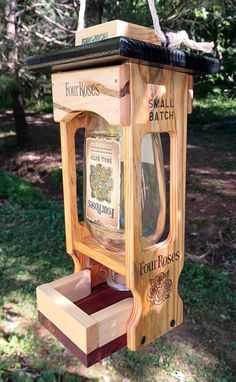 a bird feeder made out of wood and glass bottles hanging from it's side