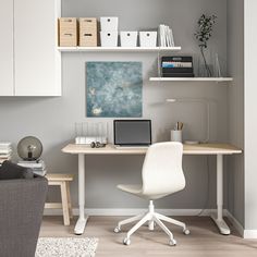 a white chair sitting next to a desk with a laptop on it