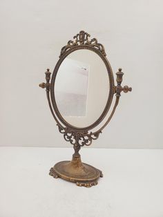 an antique looking mirror is sitting on a table